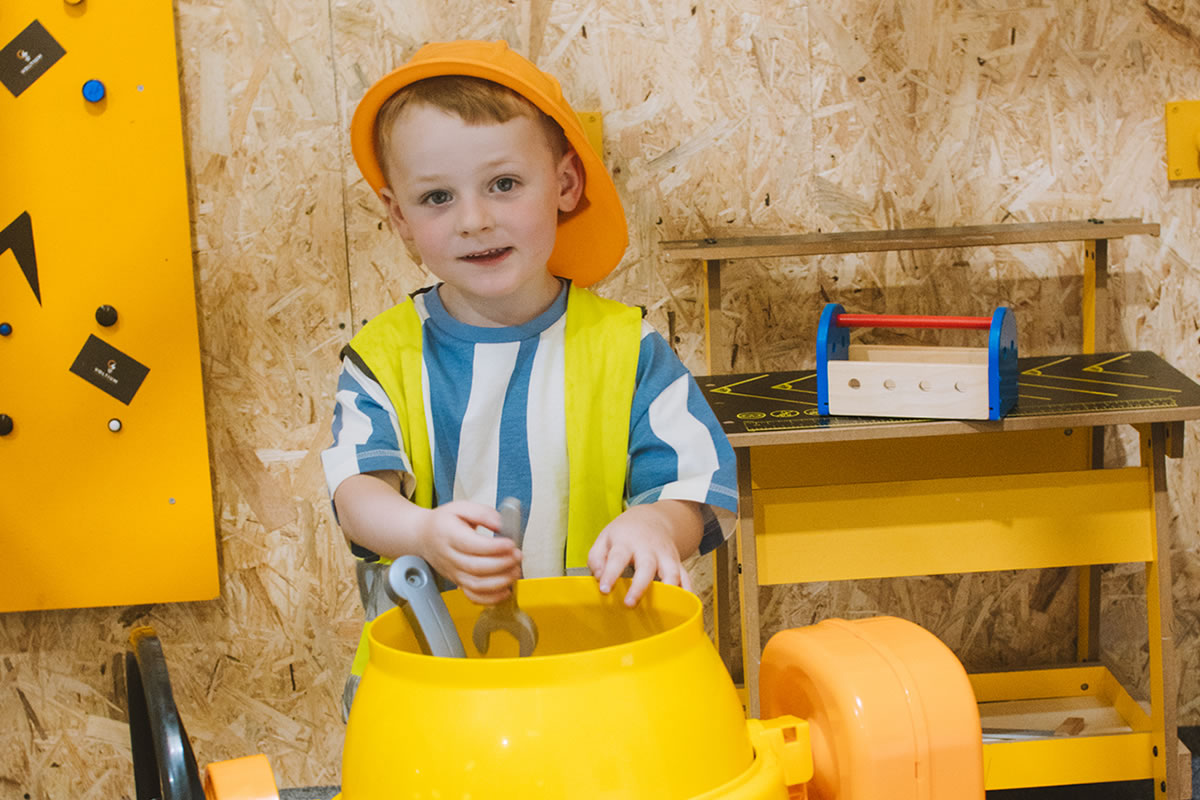 Child at cement mixer in the builders play zone at Giggle Street role play centre Shrewsbury